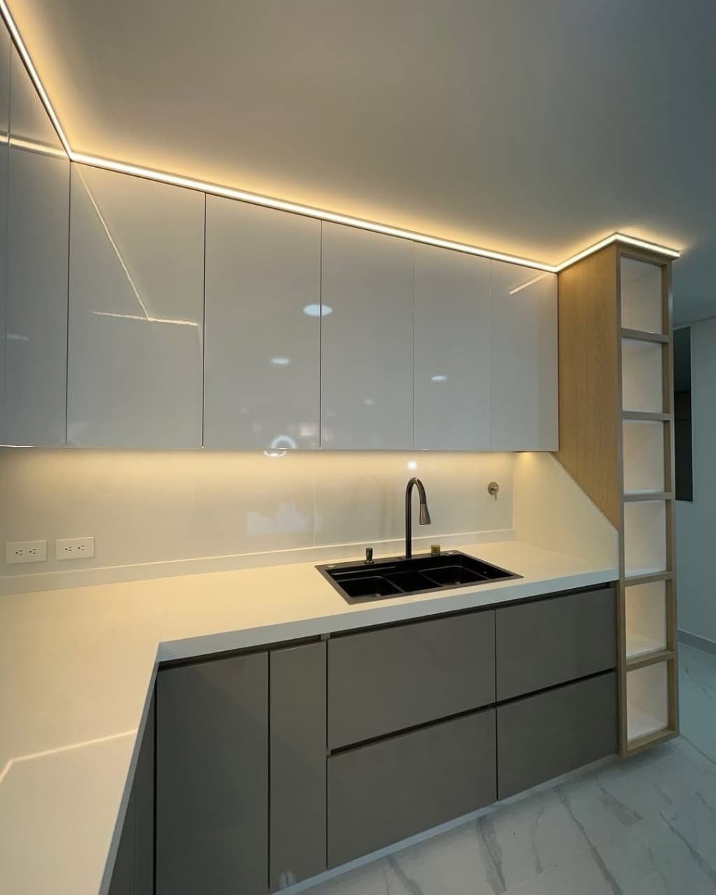 Bright white glossy upper cabinets paired with warm grey matte lowers, seamless quartz countertop, integrated sink, and warm LED strip lighting. Clean, bright, and luxe. ✨