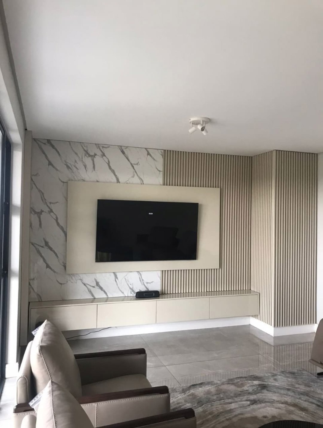 Striking marble slab paired with warm wooden slats, framed TV niche, and sleek floating console. The perfect balance of cool stone & warm texture. 🪵